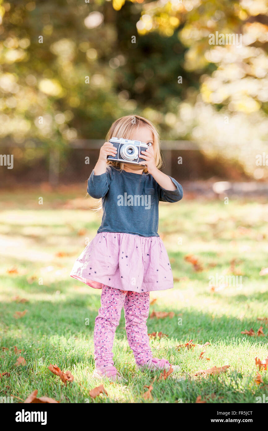 Niño Niña utilizando retro Cámara en otoño park Foto de stock