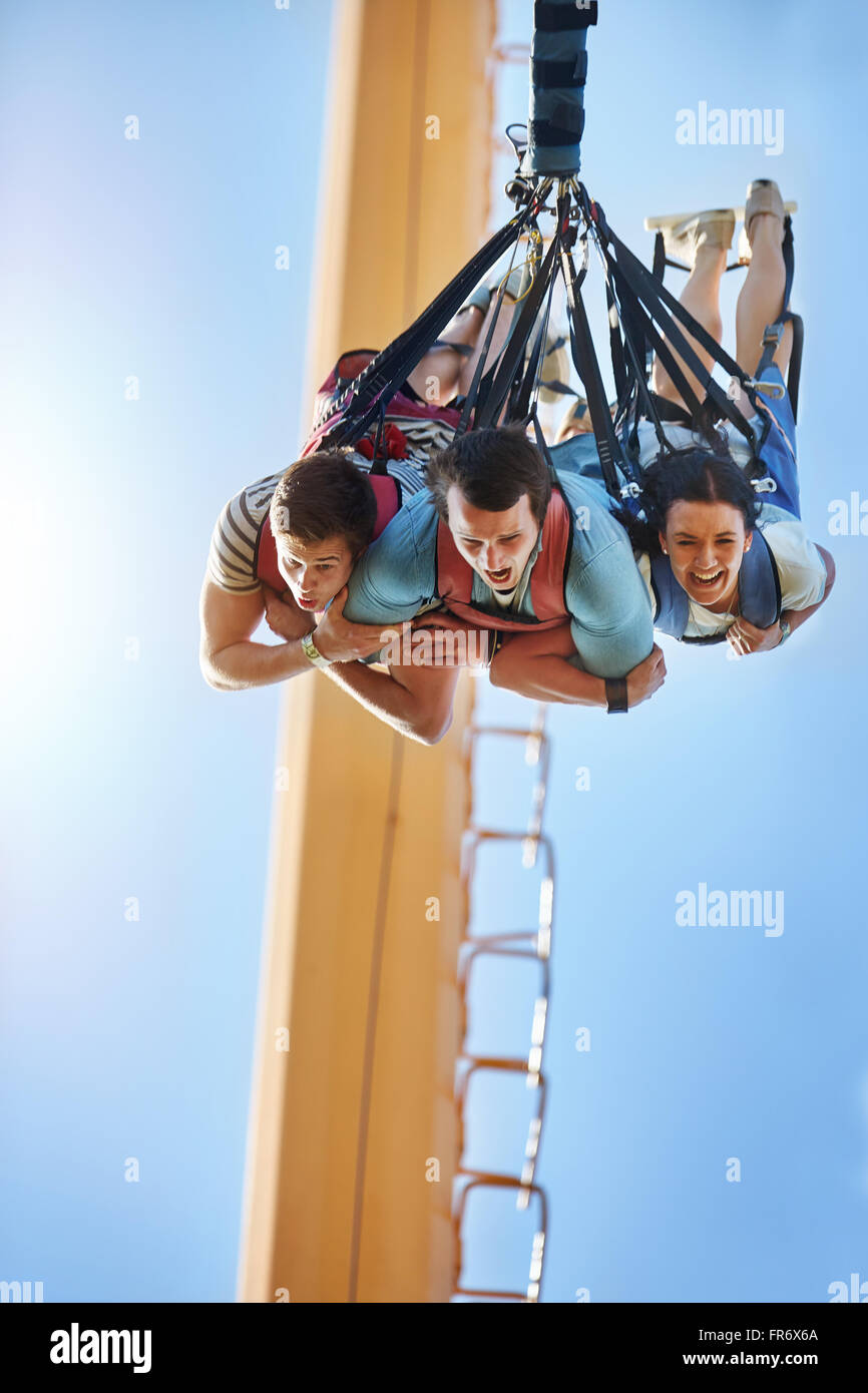 Amigos bungee jumping en parque de diversiones Foto de stock
