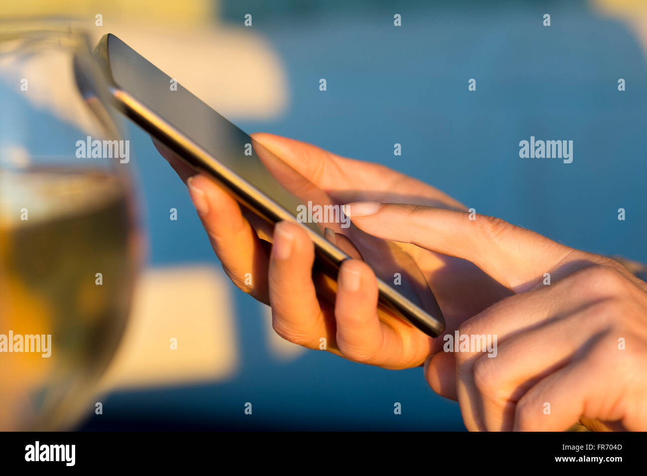 La luz del atardecer, mujer mediante teléfono móvil. Closeup manos Foto de stock