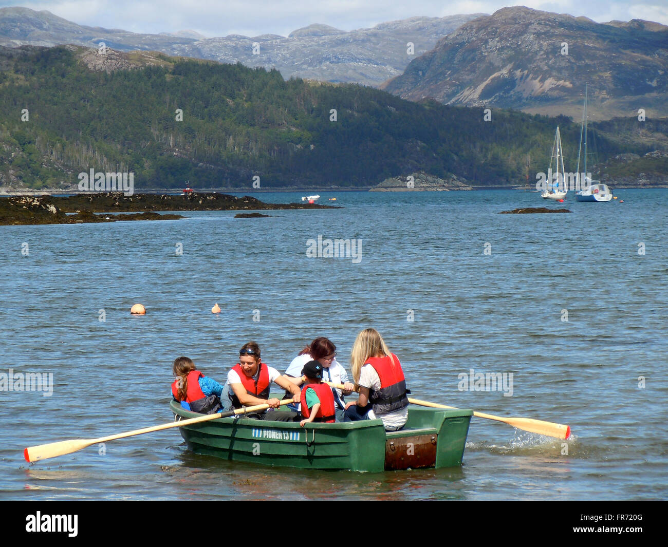 Los niños en bote a remo en Plockton, Escocia Foto de stock