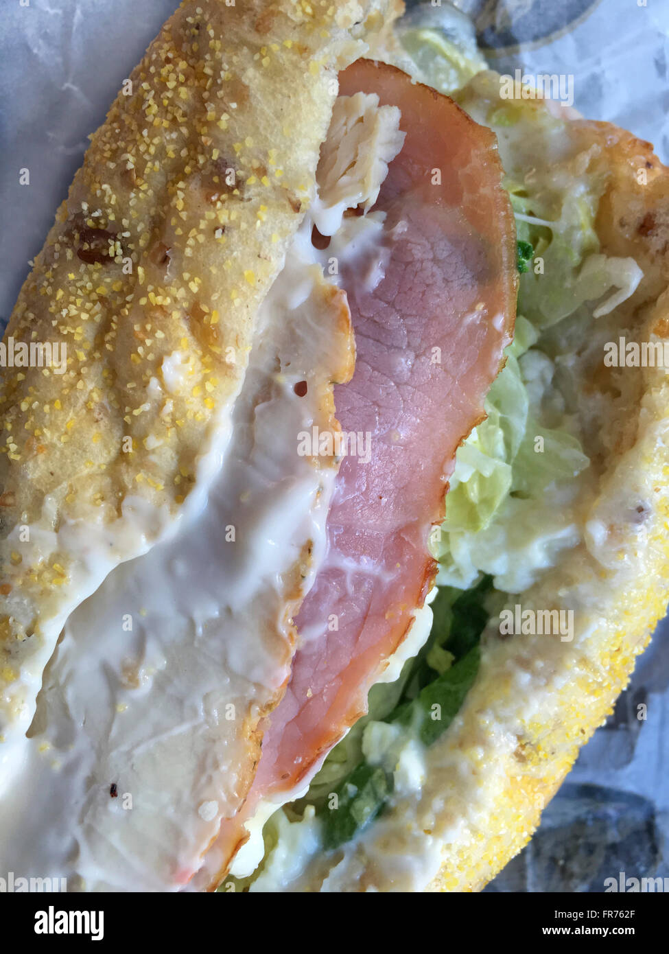 Primer plano de un submarino de sandwich con pollo, jamón, lechuga, espinaca, queso y mayonesa en multi-pan de grano. Foto de stock