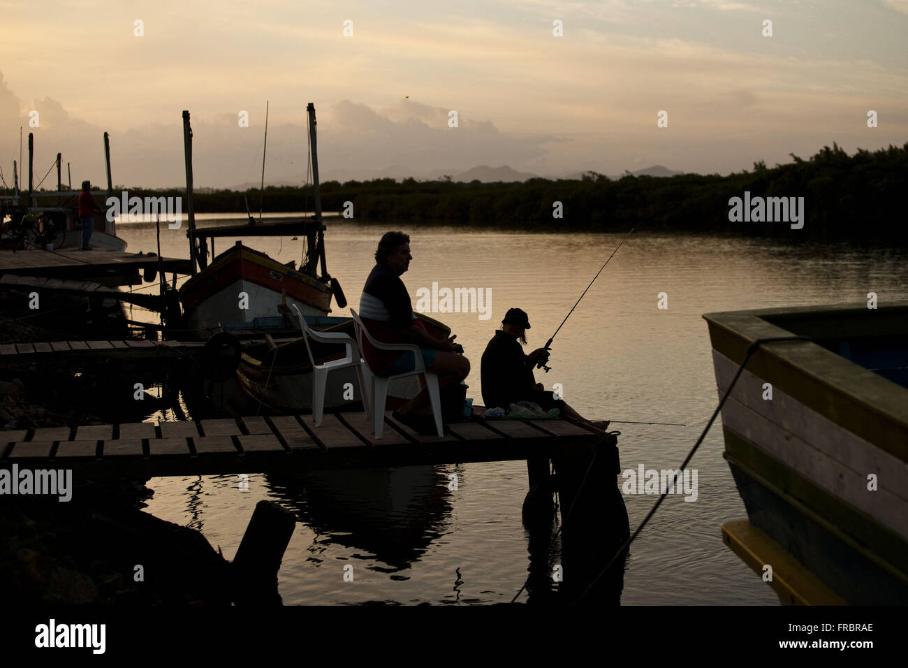 Gente pescando en el canal único en la costa de Santa Catarina al atardecer Foto de stock