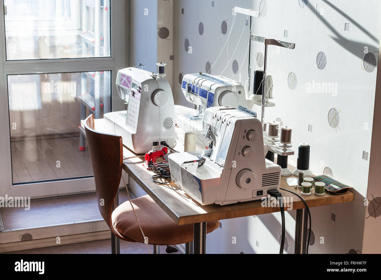 Taller de costurera en casa - máquinas de coser y serger en mesa Fotografía  de stock - Alamy