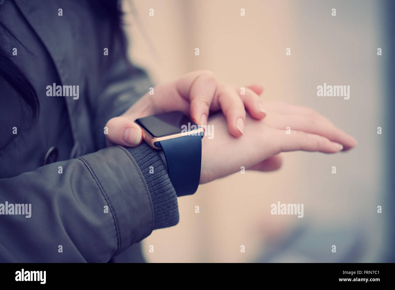 Cerca de las mujeres de moda utilizando Smart Watch, haciendo clic en los botones. Esta moderna tecnología permite conectarse libremente a internet y a las redes de medios de comunicación social desde donde quiera Foto de stock