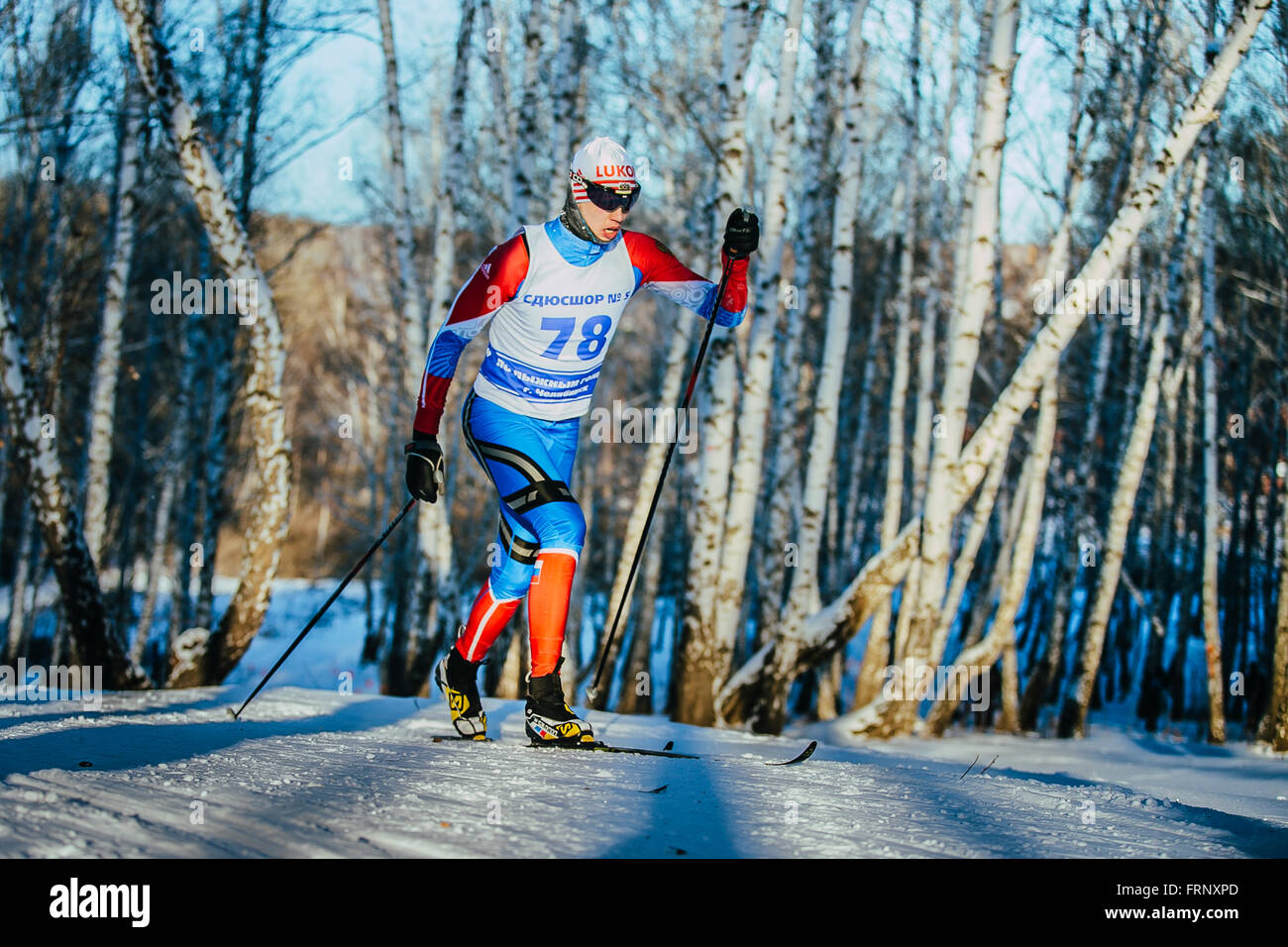 Joven atleta masculino raza esquiadores en invierno bosque estilo clásico caballo cuesta arriba durante el campeonato de Chelyabinsk en cross-country Foto de stock