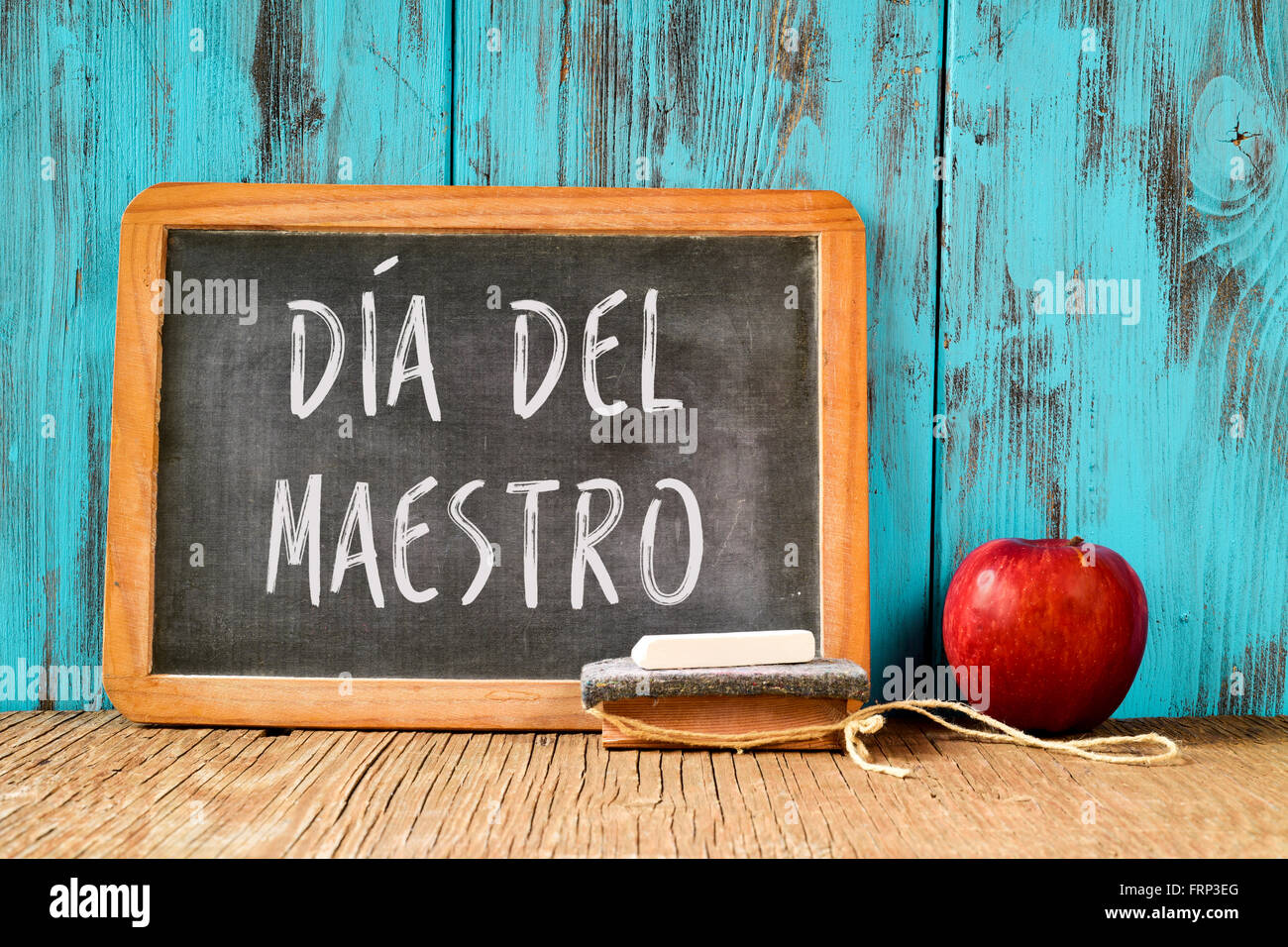Una pizarra con el texto dia del maestro, el día del maestro escrito en  español, un pedazo de tiza, Borrador y una manzana roja sobre una ru  Fotografía de stock - Alamy