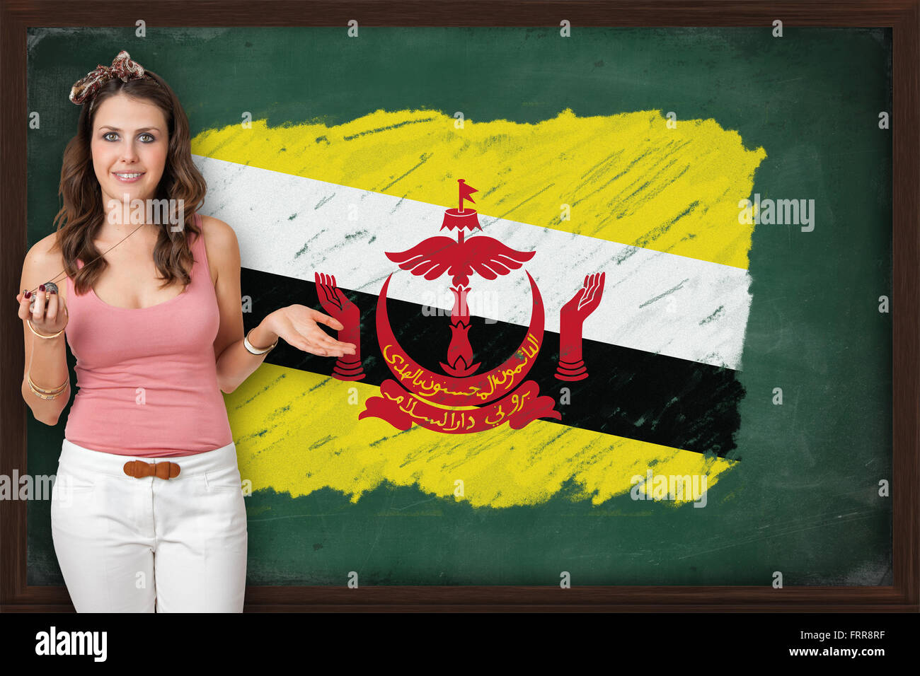 Hermosa mujer sonriente y mostrando la bandera de Brunei por Blackboard, presentación para el turismo y la investigación de marketing Foto de stock