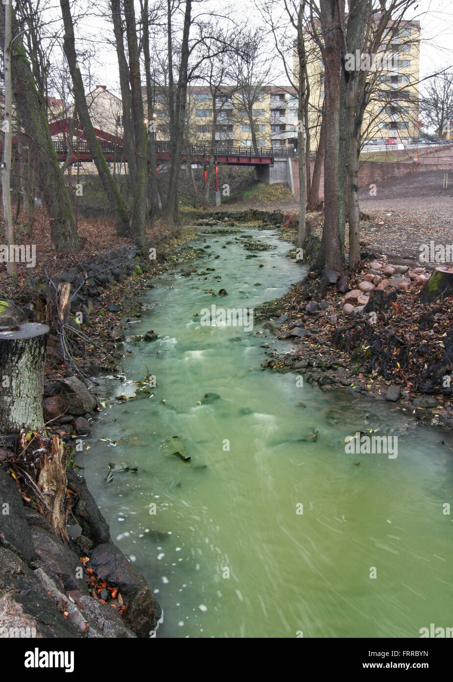 Río contaminado en el ambiente urbano. Foto de stock
