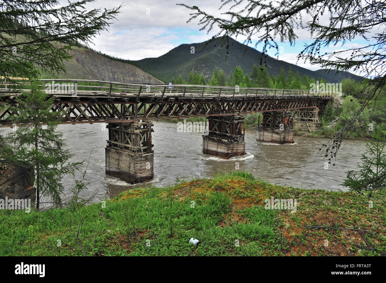 La autopista federal 'Kolima' cruza el río Suntar sobre el puente de madera. Foto de stock
