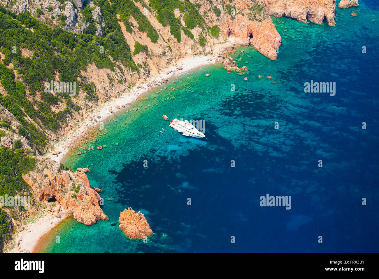 Córcega, isla francesa en el Mar Mediterráneo. El paisaje costero con rocas y placer yate a motor, a vista de pájaro Foto de stock