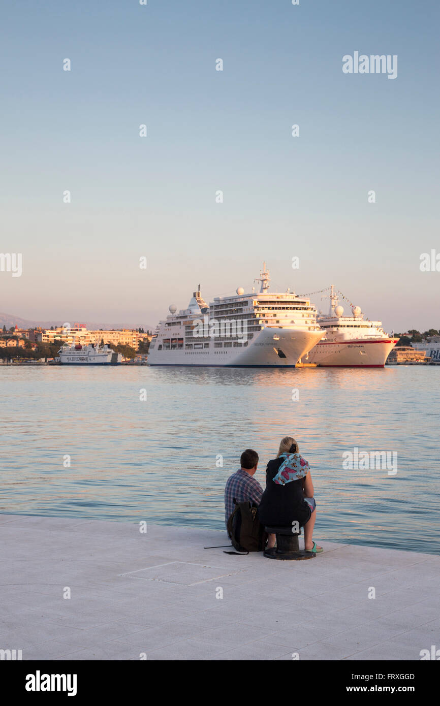 Pareja en el muelle con barcos de crucero MV Silver Spirit, Silversea Cruises, y MS Deutschland en la distancia, Split, Croacia Split-Dalmatia Foto de stock