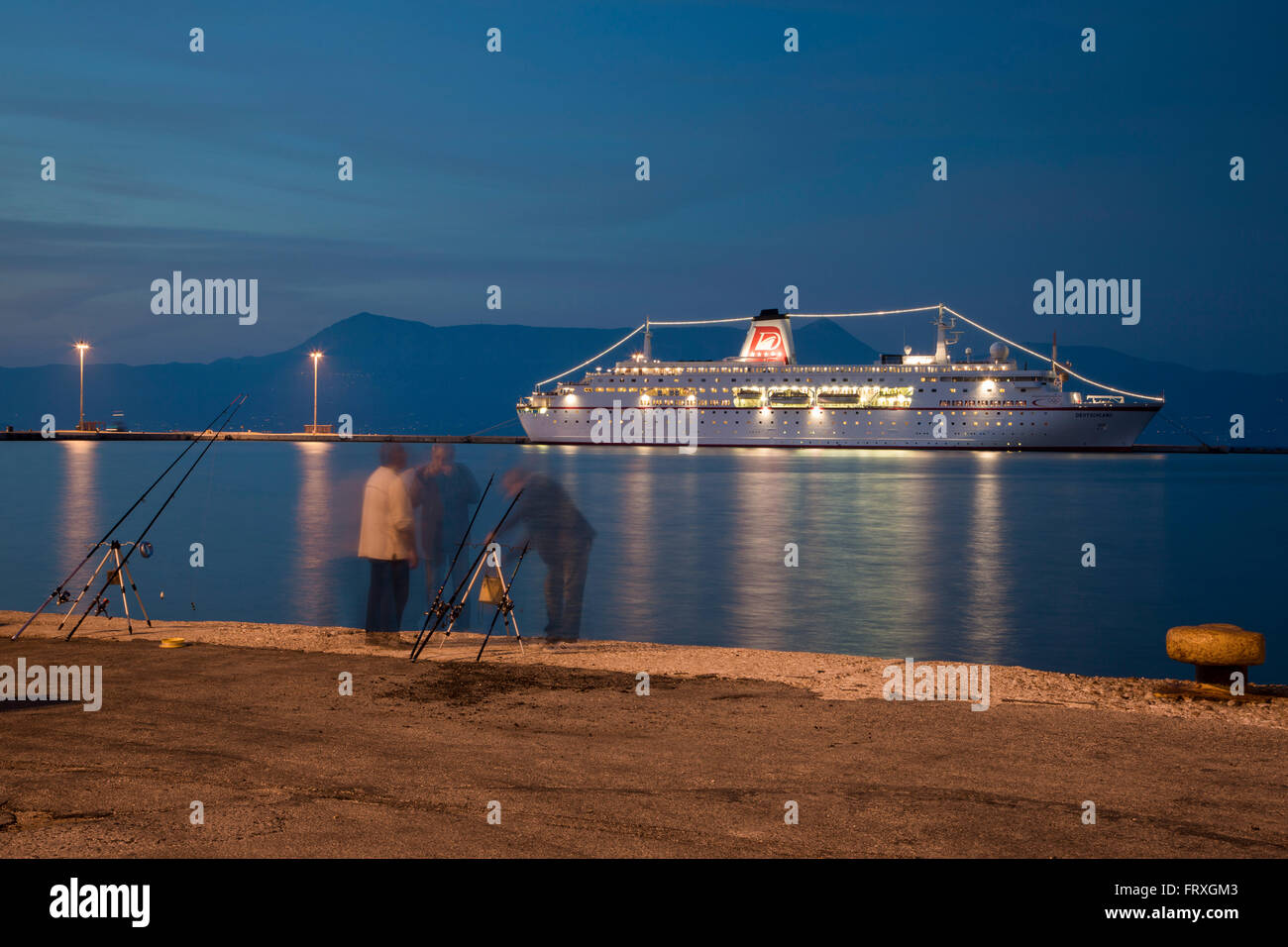 Pescadores en el muelle con el barco crucero MS Deutschland, Peter Deilmann Reederei en el fondo, al anochecer, Kerkyra, la ciudad de Corfu, Corfú, las Islas Jónicas, Grecia Foto de stock