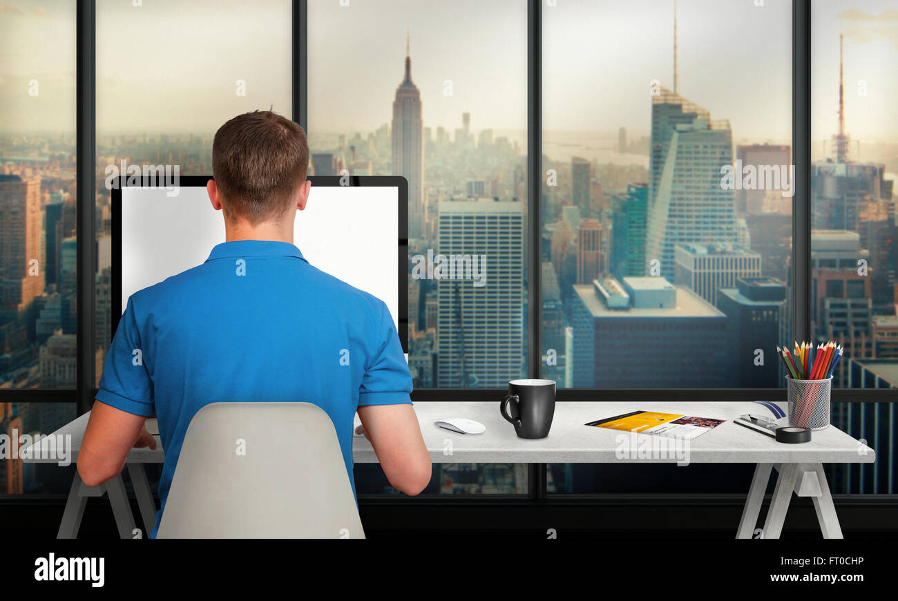 Hombre trabajando en un equipo con pantalla aislados en el interior de la oficina con vistas a la ciudad y los rascacielos. Escritorio de trabajo con teclado, m Foto de stock