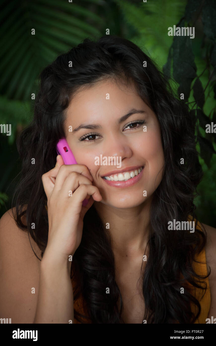 Sonriente joven mujer hispana con teléfono celular - Puerto Vallarta, México #613PV Foto de stock