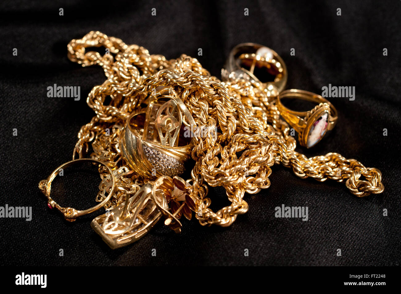 Chatarra de joyas de oro incluyendo cadenas, pulseras y en un fondo negro Fotografía de stock Alamy