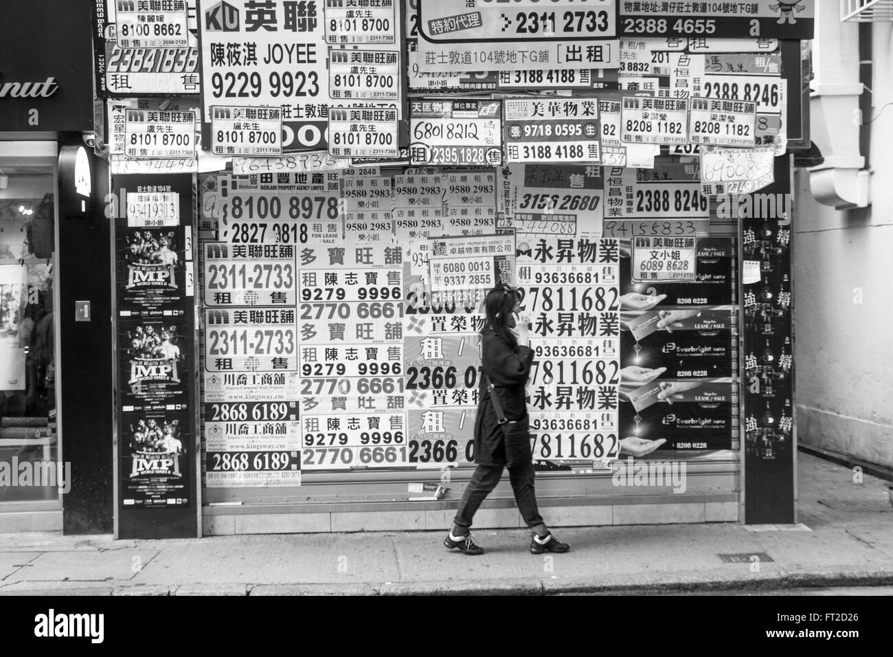Alquiler inmobiliaria publicidad quiosco de números de teléfono en Hong Kong en blanco y negro Foto de stock