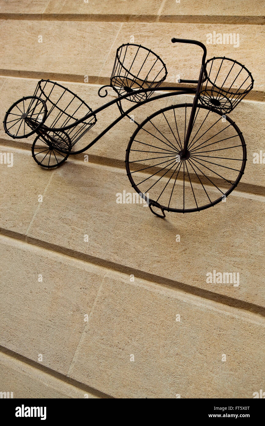 ladrón barricada Montaña Bicicleta de hierro forjado para apoyar las macetas sobre una pared de  piedra Fotografía de stock - Alamy