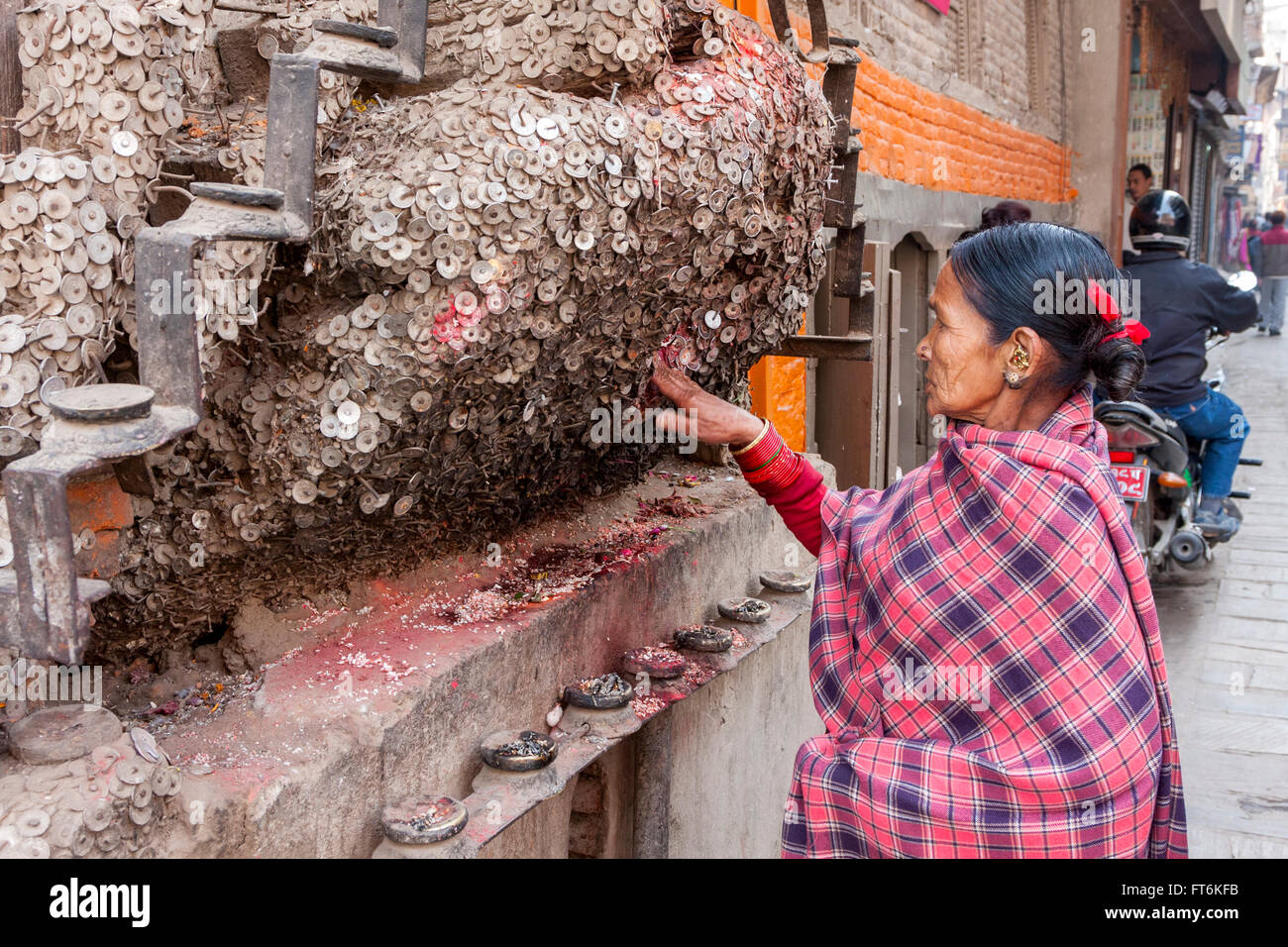 Nepal, Katmandú. Mujer rezando por ningún dolor de muelas en el santuario para el dolor de muelas, Dios Bangemudha Square. Foto de stock
