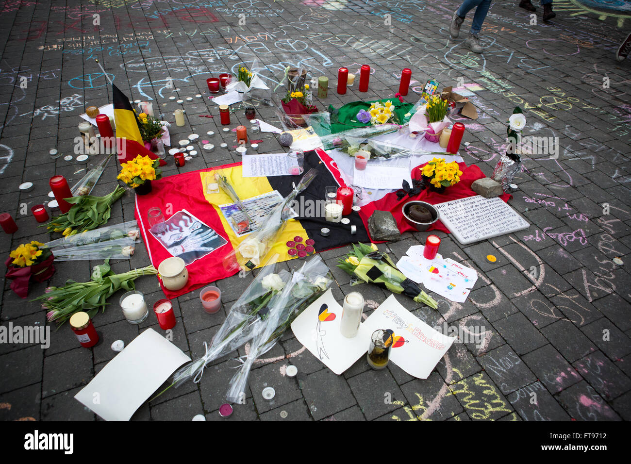 Namur, Bélgica. 25 Mar, 2016. Mensajes, dibujos, flores, velas sentar alrededor de una bandera belga durante el homenaje a las víctimas de los ataques terroristas del 22 de marzo en Bruselas en Namur, Bélgica. Crédito: Frédéric de Laminne/Alamy Live News Foto de stock