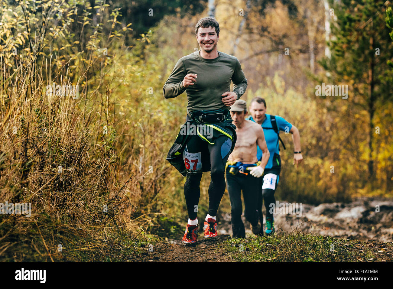 Beloretsk, Rusia - Septiembre 26, 2015: hermosa sonriente hombre corriendo en el bosque de otoño durante el maratón de montaña "Big Iremel' Foto de stock