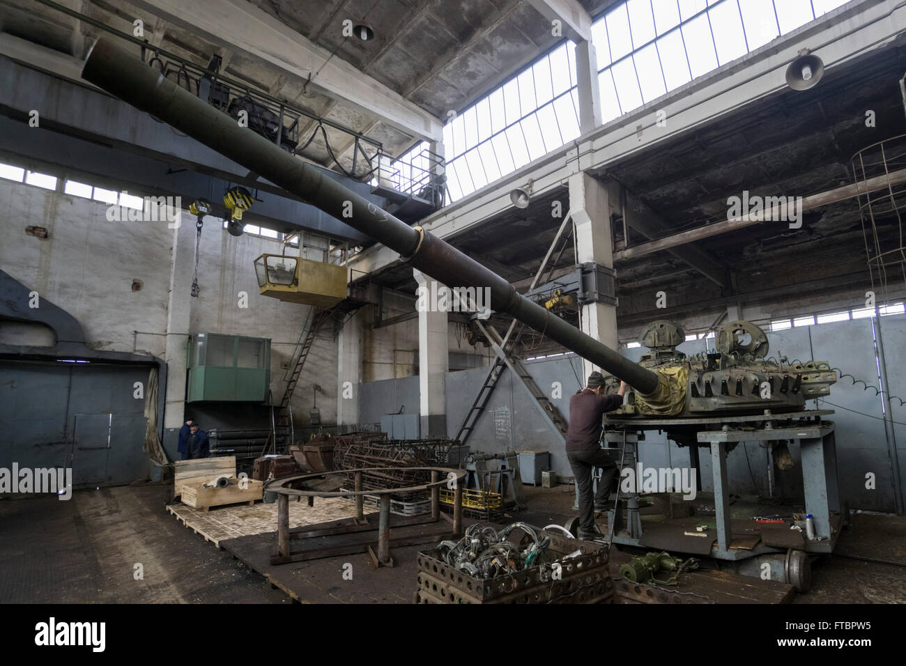 Un trabajador sube a la torreta de un tanque en reparación en la planta de  armadura de Lviv Fotografía de stock - Alamy