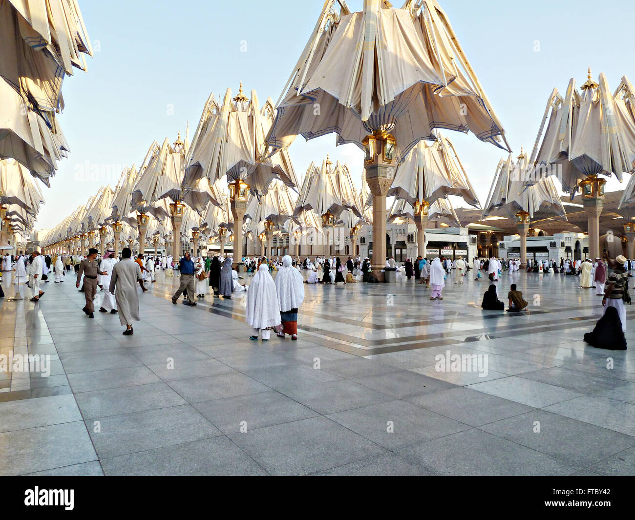 Miles de peregrinos Hajj musulmán descansar y relajarse bajo las sombrillas  Nabwi Masjid cerrarse para permitir al sol en la Meca, Al-Hejaz, Arabia  Saudita. El gigante de alta tecnología sombrillas ofrecen protección