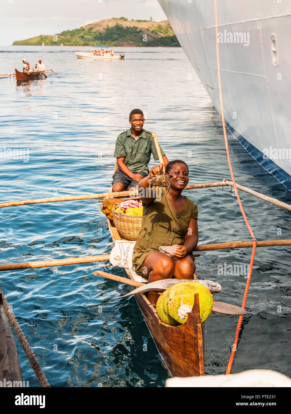 Proveedores malgache desde sus canoas de batanga ofrecen cangrejos, peces y frutas tropicales a los pasajeros del barco Foto de stock