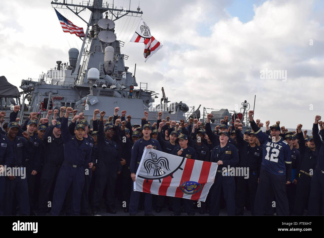 151120-N-ZT773-001 DEL OCÉANO ATLÁNTICO (Nov. 20, 2015) Los marineros a bordo del USS Carney (DDG 64) film un espíritu spot para el próximo juego de la Marina y del ejército con la bandera de batalla del buque y el fondo nacional de ensign en Noviembre 20, 2015. Carney, un Arleigh Burke clase destructor de misiles guiados, desplegadas a Rota, España, está realizando un patrullaje de rutina en los EE.UU. 6ª Flota de la zona de operaciones en apoyo de los intereses de seguridad nacional de EE.UU. en Europa. (Ee.Uu. Foto de la Marina por el teniente J.G. Jessica Bronson/ liberado) Foto de stock