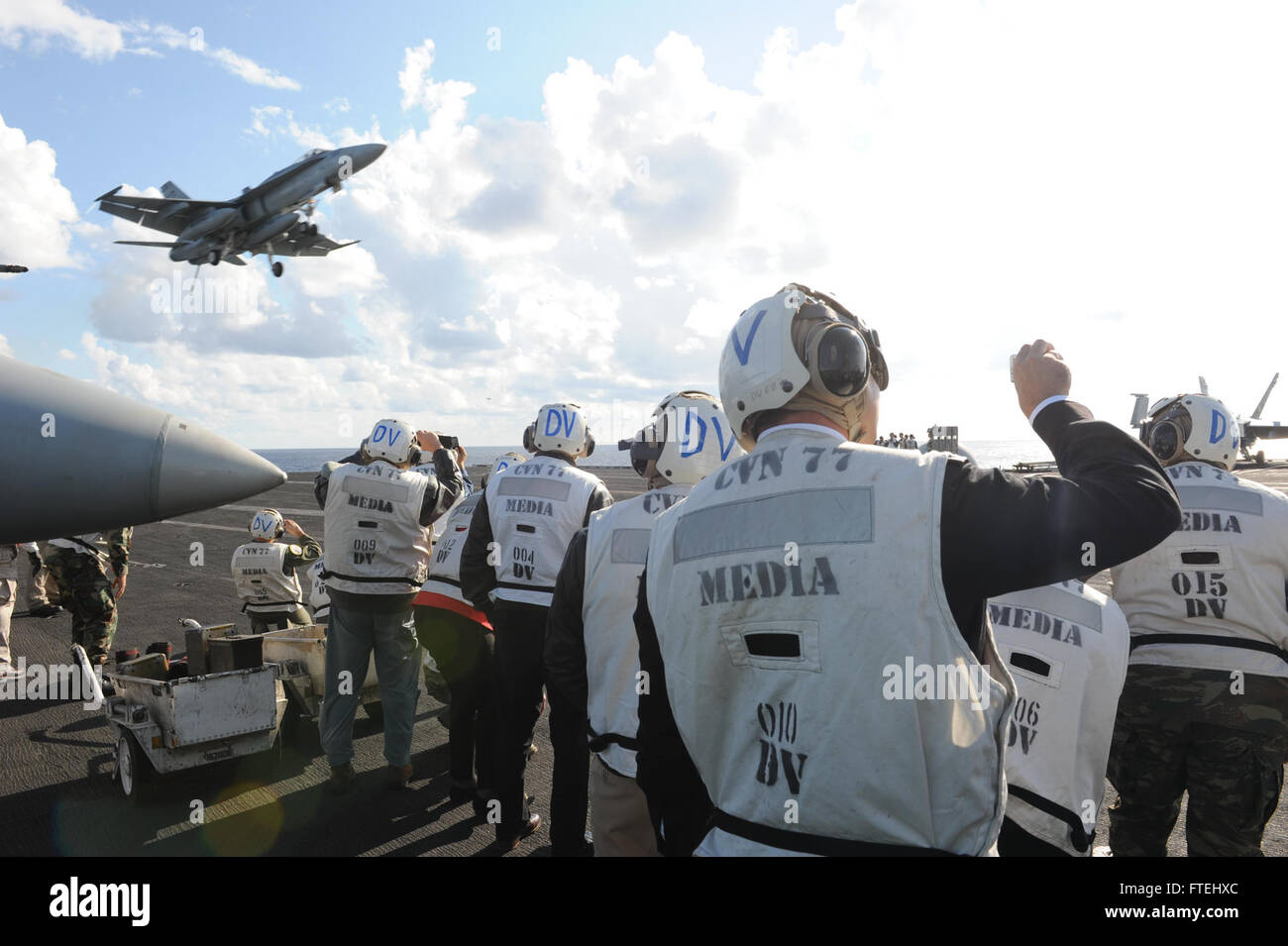 Mar Mediterráneo (Oct. 29, 2014) distinguidos visitantes fotografiar un F/A-18 Hornet que aterriza en la cubierta de vuelo del portaaviones USS George H.W. Bush (CVN 77). George H.W. Bush, homeported en Norfolk, Virginia, es la realización de las operaciones navales en los EE.UU. 6ª Flota de la zona de operaciones en apoyo de los intereses de seguridad nacional de EE.UU. en Europa. Foto de stock