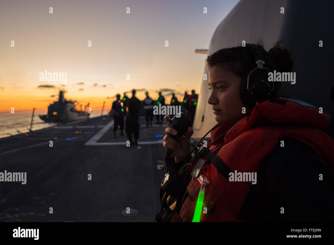 Mar Mediterráneo (Nov. 16, 2014) - Sónar técnico de 3ª clase de superficie Cecilia Meza, de Mesquite, Texas, mantiene como lector de teléfono a bordo del USS Cole (DDG 67) durante una reposición en el mar con el USNS Leroy Grumman TAO (95). Cole, un Arleigh Burke clase destructor de misiles guiados homeported en Norfolk, está realizando operaciones navales en los EE.UU. 6ª Flota de la zona de operaciones en apoyo de los intereses de seguridad nacional de EE.UU. en Europa. Foto de stock