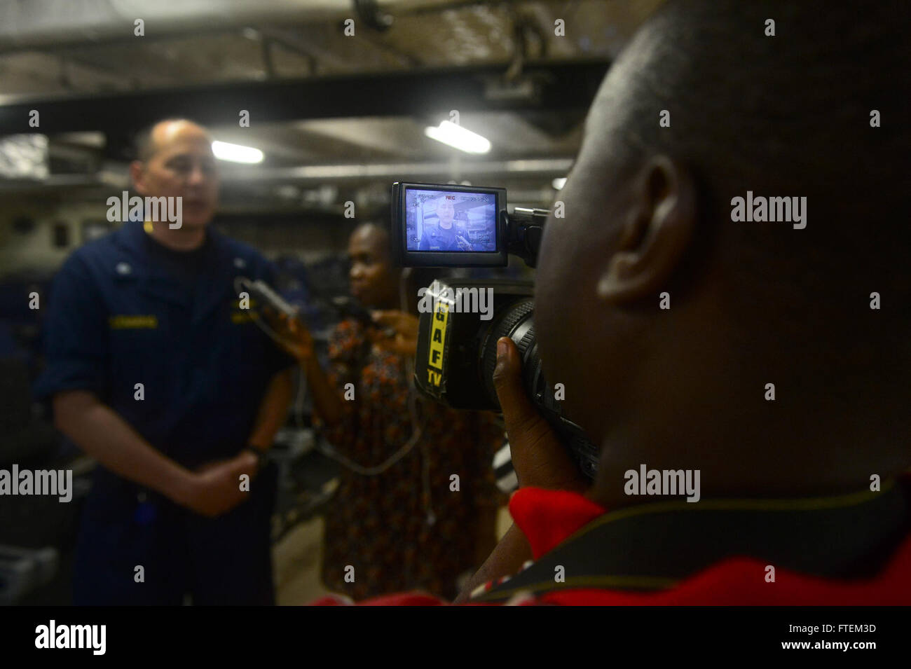 Océano Atlántico (Feb. 21, 2015), Comandante de la Misión de la estación de Asociación África Cmdr. Mateo Flemming, de Virginia Beach, Virginia, habla con el personal de los medios de comunicación de Ghana se embarcó a bordo del Transporte Marítimo Militar Conjunta del comando de buques de alta velocidad JHSV USNS Spearhead (1) durante la aplicación del Derecho marítimo Asociación África 2015 21 Feb, 2015. Spearhead es una implementación programada para la 6ª Flota de EE.UU. zona de operaciones en apoyo de la colaboración internacional en el programa de fomento de la capacidad de la estación de colaboración en África. Foto de stock