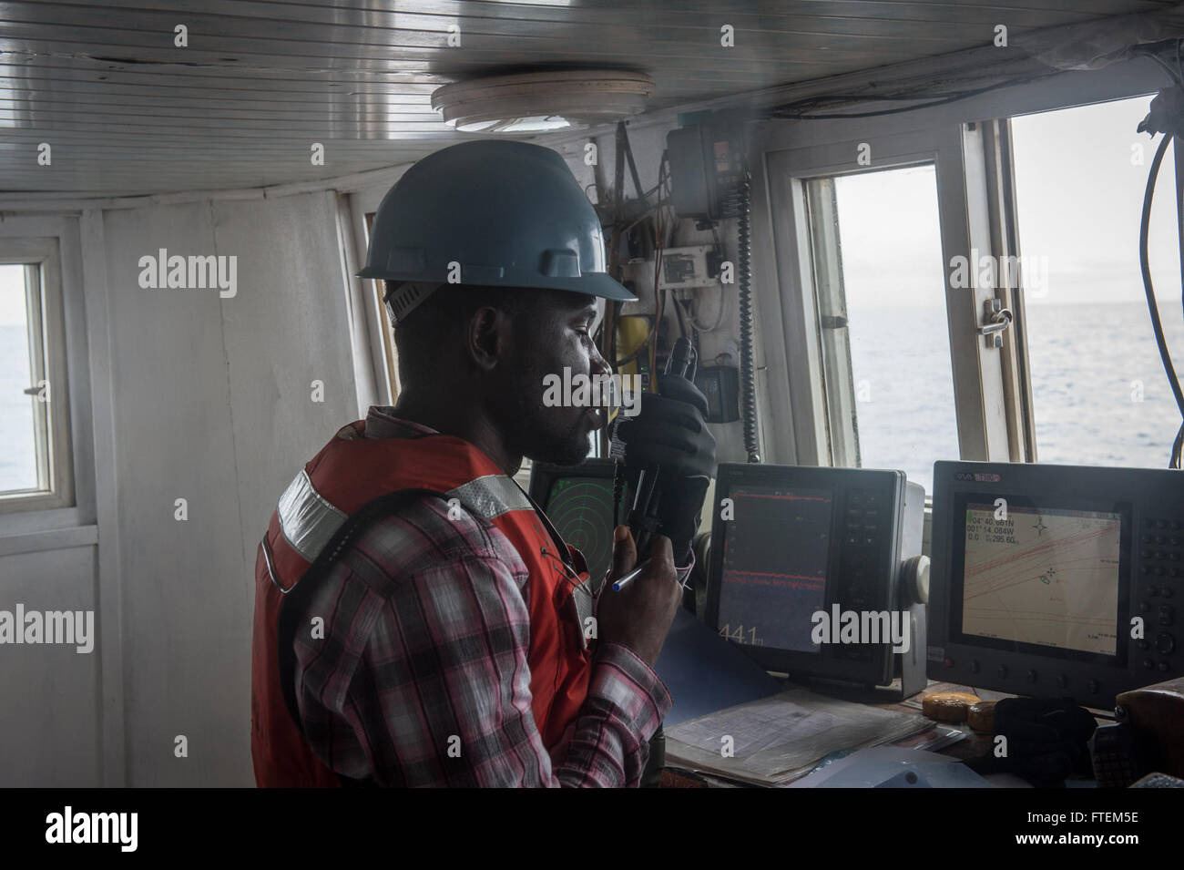 Océano Atlántico (Feb. 23, 2015), un oficial de la policía ghanesa embarcado se comunica con el comando de Transporte Marítimo Militar de alta velocidad conjunta del buque USNS Spearhead (JHSV subieron 1) de un buque de pesca marítima en África durante el cumplimiento de la Ley de asociación, el 23 de febrero de 2015. Spearhead es una implementación programada para la 6ª Flota de EE.UU. zona de operaciones en apoyo de la colaboración internacional en el programa de fomento de la capacidad de la estación de colaboración en África. Foto de stock