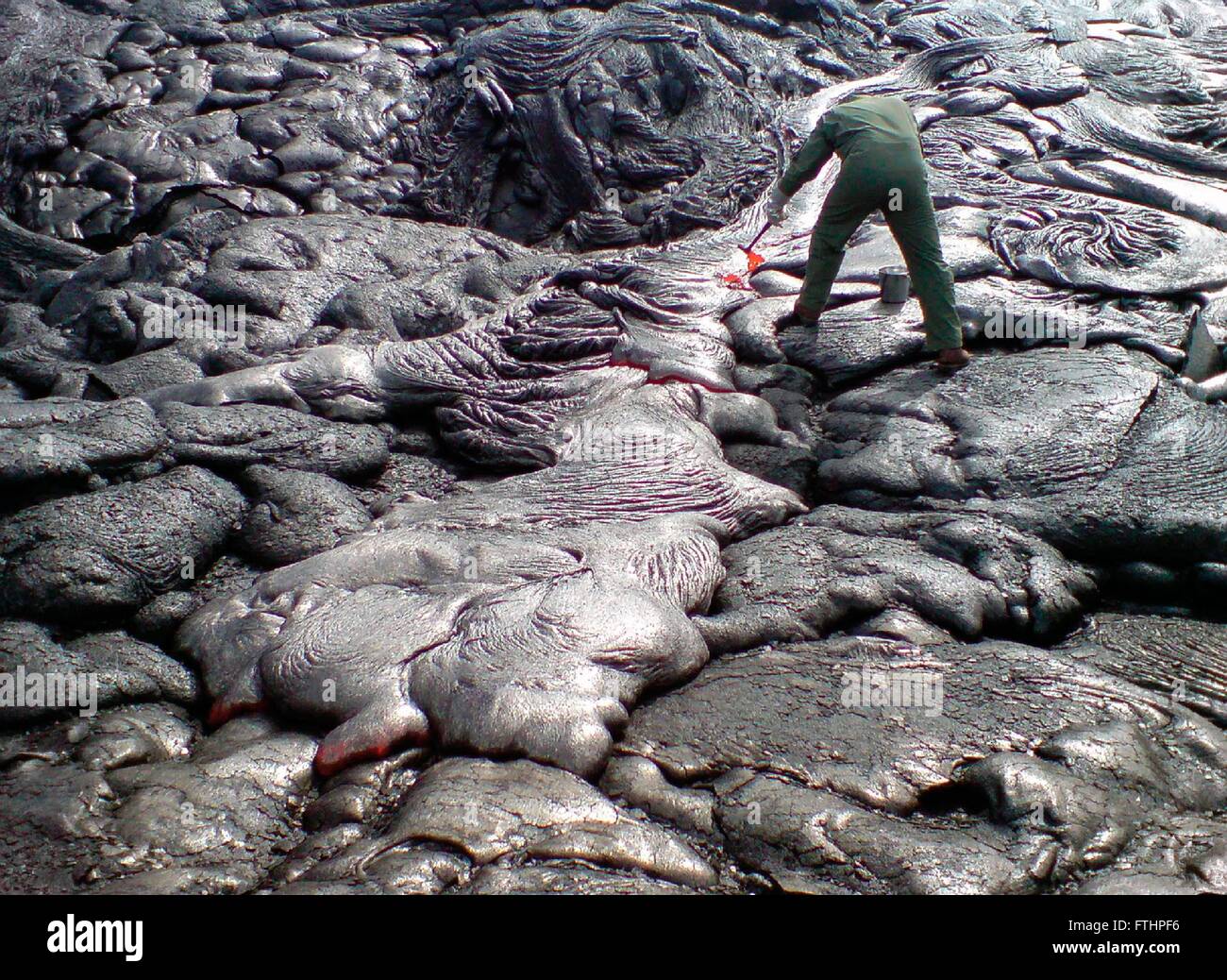Un geólogo del USGS en el Hawaiian Volcano Observatory toma muestras de