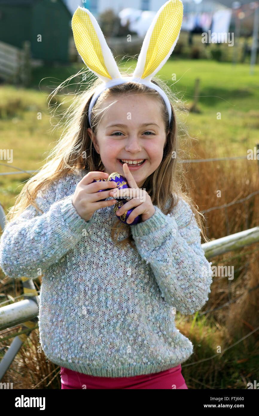 Orejas de conejo en una niña de siete años, mientras que en una búsqueda del huevo de pascua Foto de stock