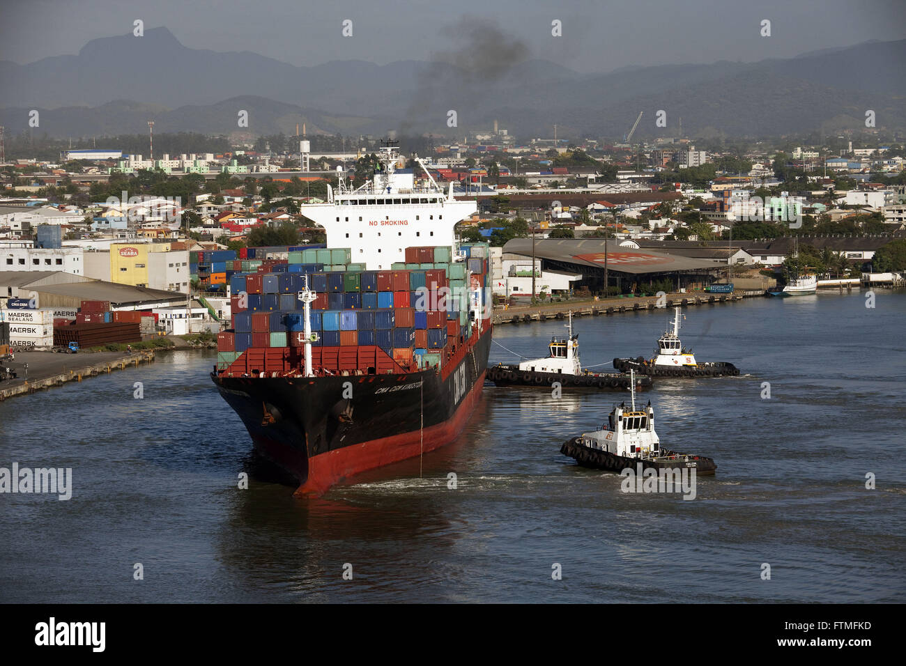 Carguero saliendo del puerto de Itajaí, seguido por los remolcadores Foto de stock