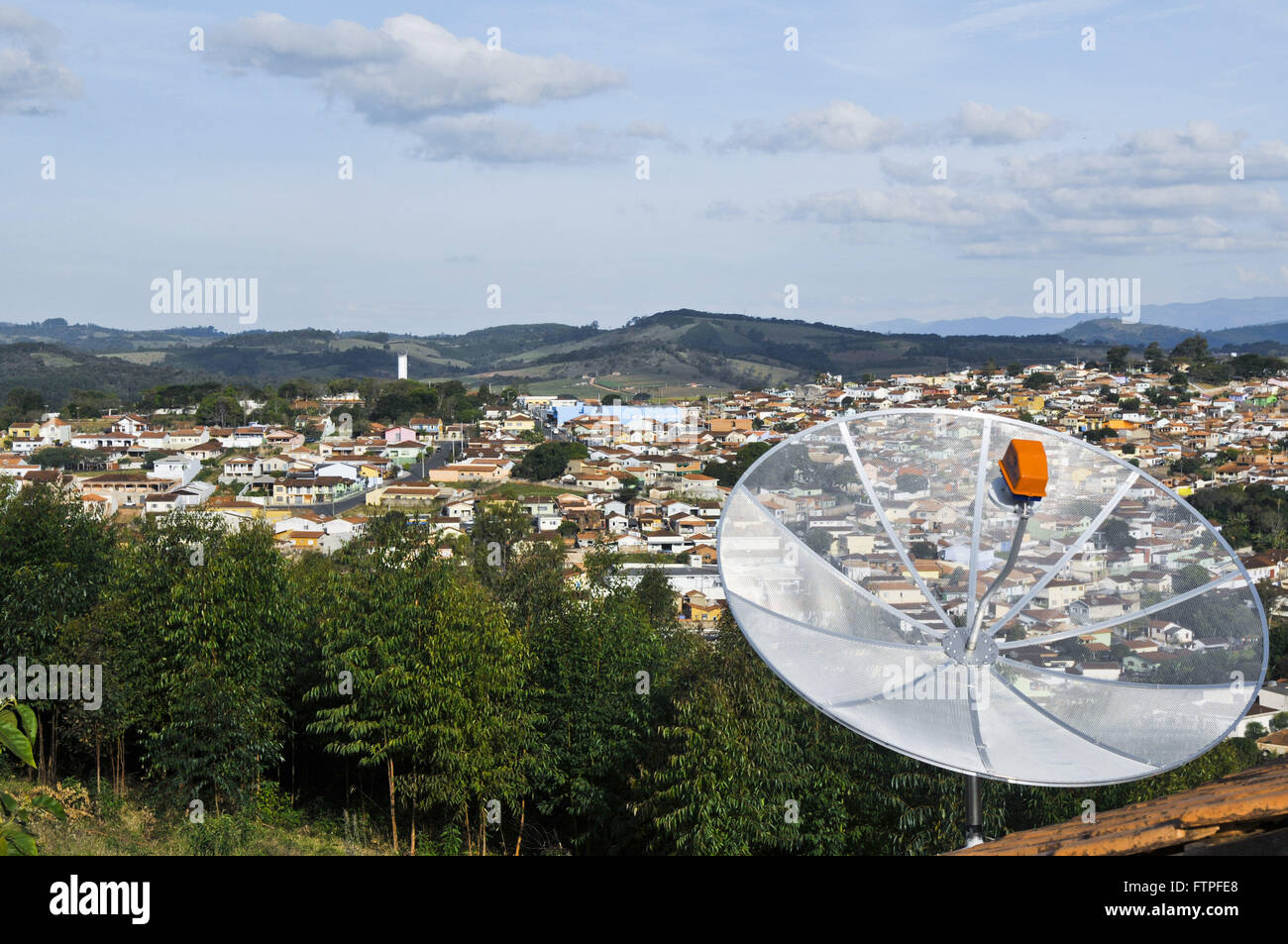 Resalte de antena parabólica, vivienda y vistas a la ciudad en el fondo Foto de stock
