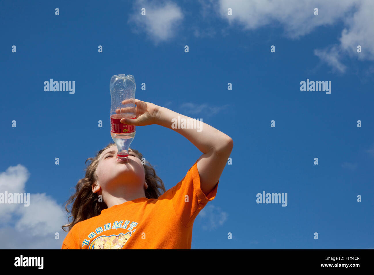 Una Joven Toma Un Merecido Descanso En La Cima De Una Colina Como Ella Bebe Agua De Una Botella De Plastico Despues De Caminar Hasta La Cima Mientras Observaba A La Vista