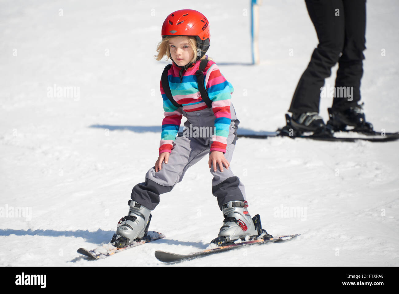 Niña en las pistas de esquí con cascos y gafas de esquí Fotografía de stock  - Alamy