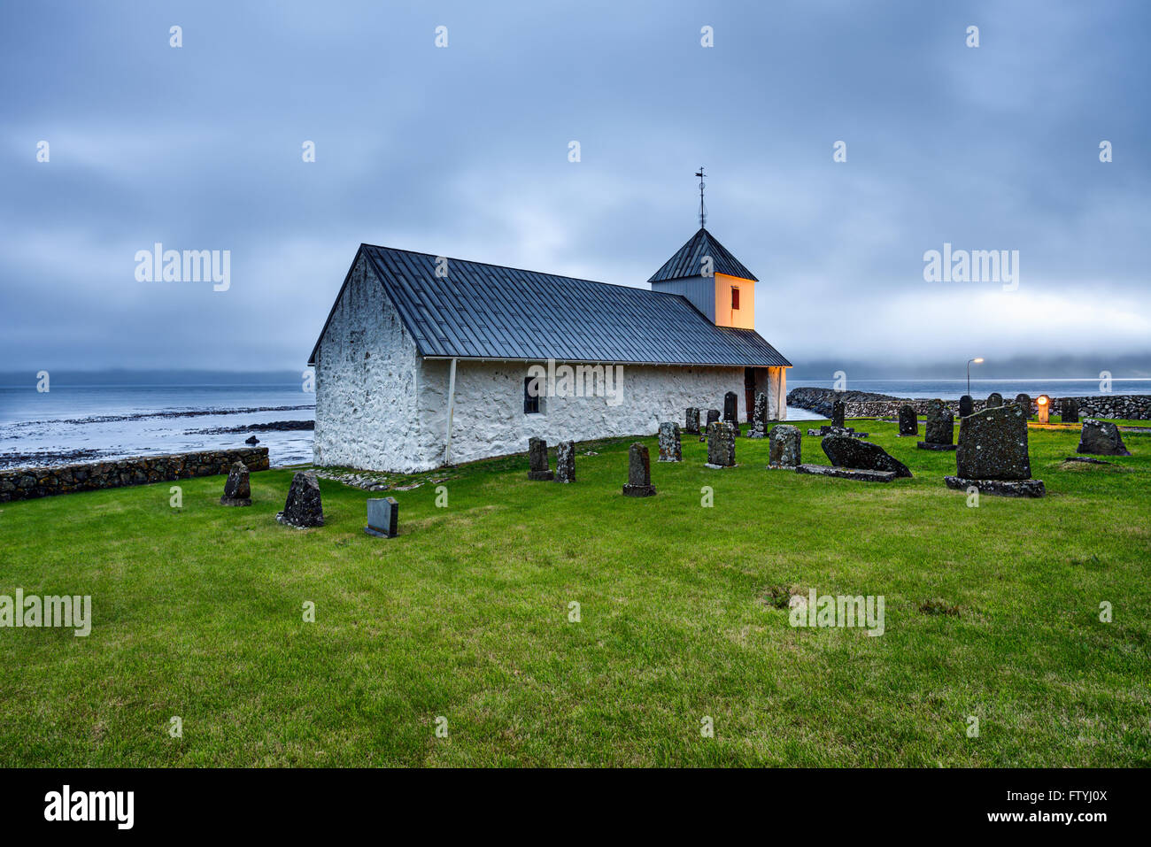 Pequeña iglesia con cementerio en la aldea de Kirkjubour, Islas Feroe, Dinamarca Foto de stock