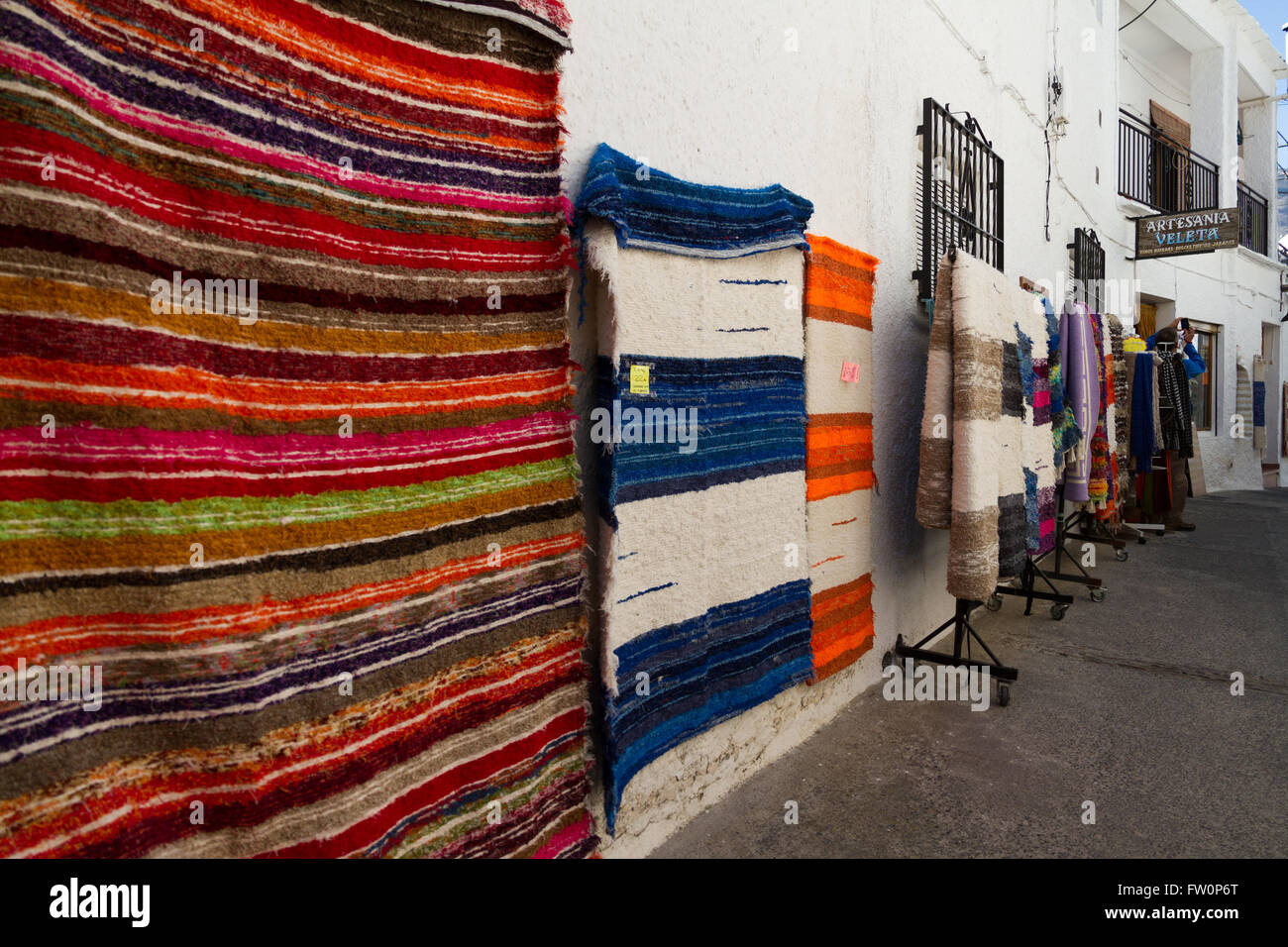 Alfombras colgando fuera shopes tradicional en el pueblo andaluz de  Pampaneira en la Alpujarra Fotografía de stock - Alamy