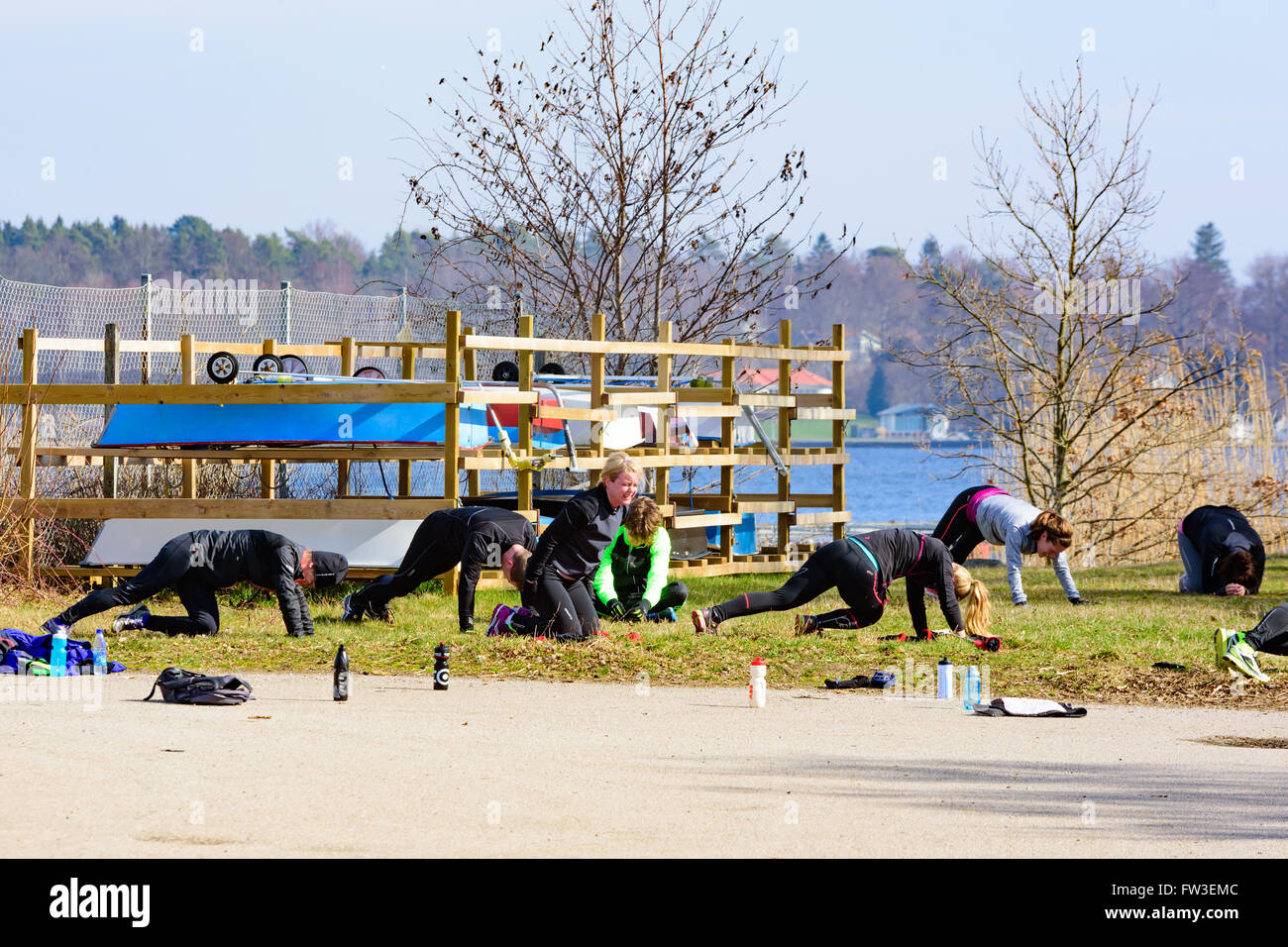 Nattraby, Suecia . Marzo 27, 2016: las personas adultas el ejercicio al aire libre cerca de la costa. Pequeñas embarcaciones presentes en el backgroun Foto de stock