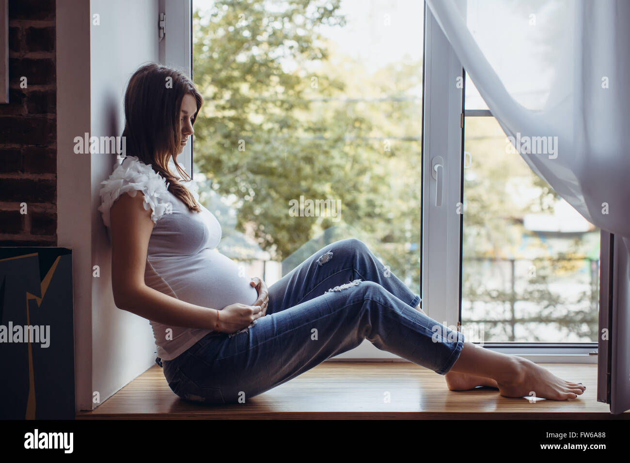 Mujer embarazada en jeans fotografías e imágenes de alta