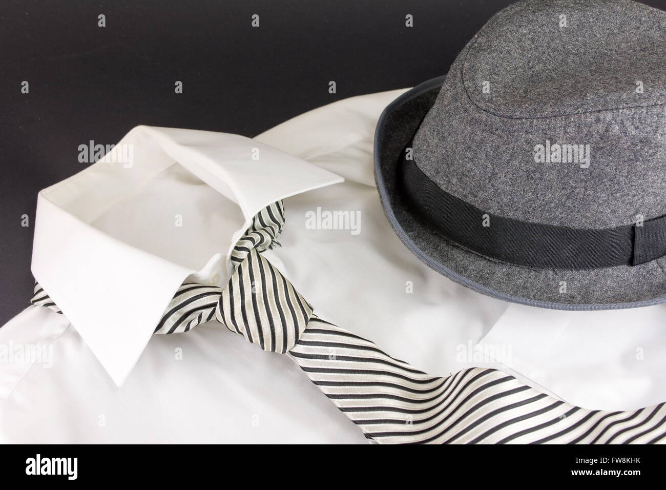 Un sombrero negro, corbata blanca y camisa stipped Foto de stock