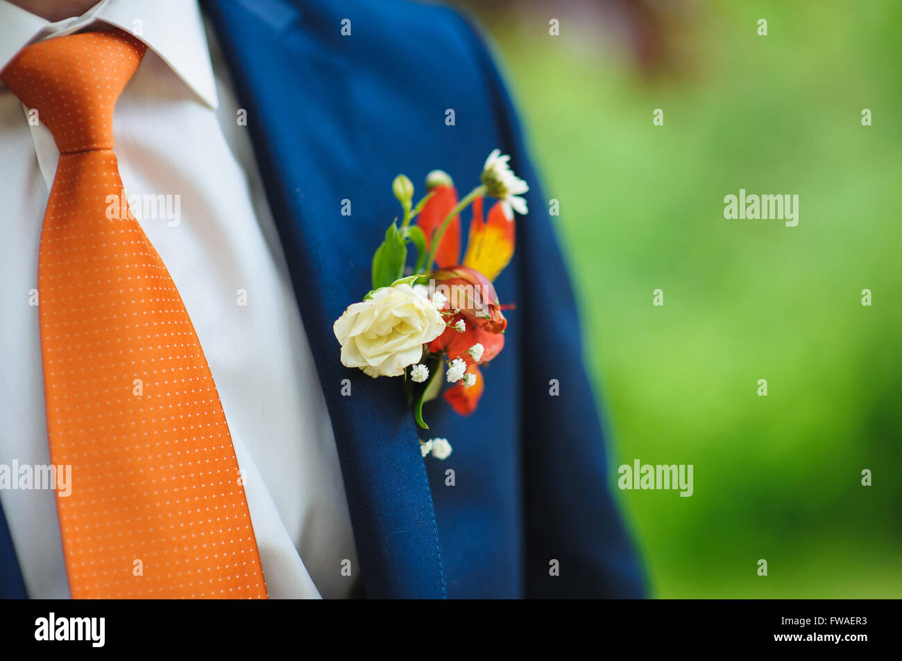 Boda en traje hermoso arreglo floral para la solapa del novio. Hombre de  traje azul, camisa y corbata naranja Fotografía de stock - Alamy