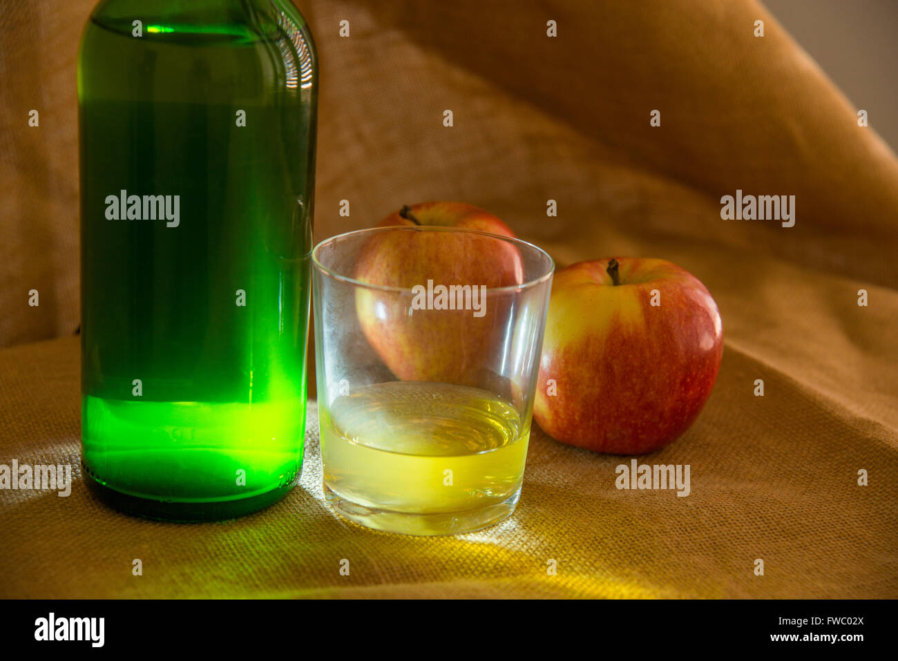 Botella y copa de sidra y dos manzanas. Asturias, España. Foto de stock
