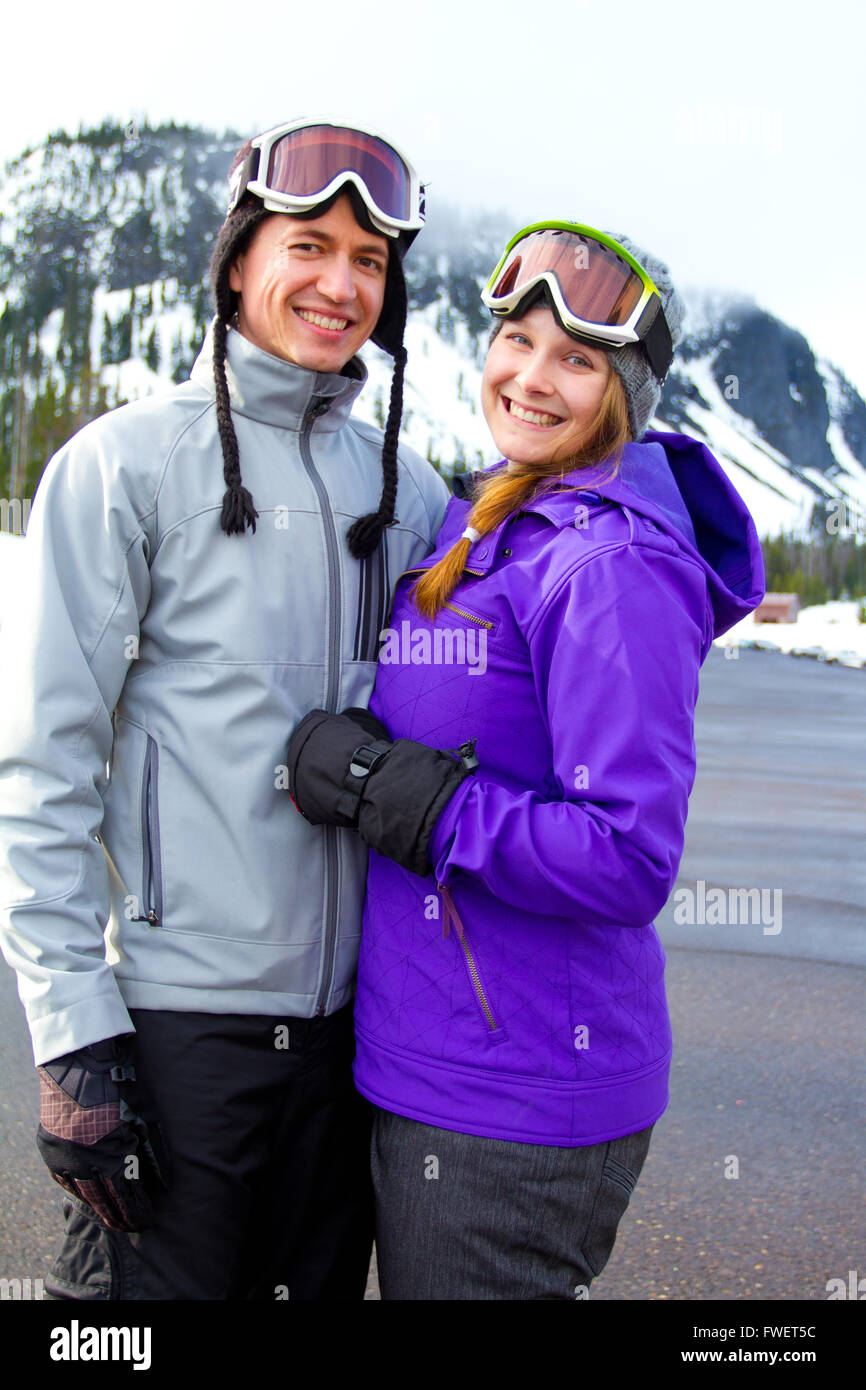 Una pareja feliz juntos en el resort de montaña en la nieve de un día de esquí y snowboard. Foto de stock
