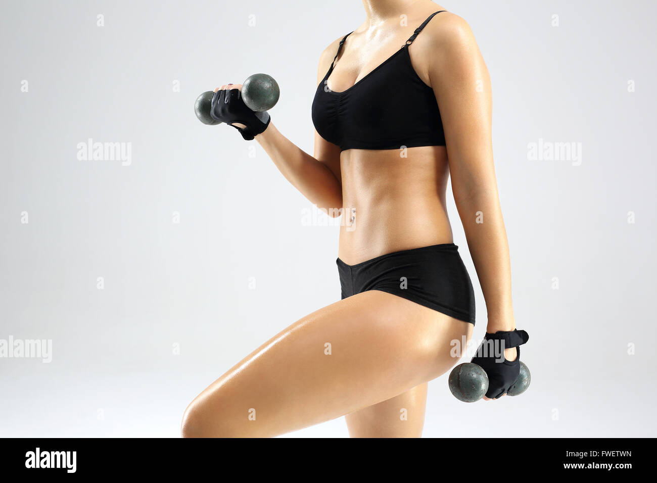 Mujer ropa practicar fitness. El cuerpo de una mujer, la actividad física.  Mujer de vestimenta deportiva eleva las pesas Fotografía de stock - Alamy