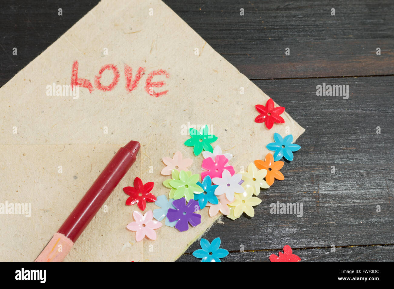 Amor palabra manuscrita en papel con flores artificiales Foto de stock