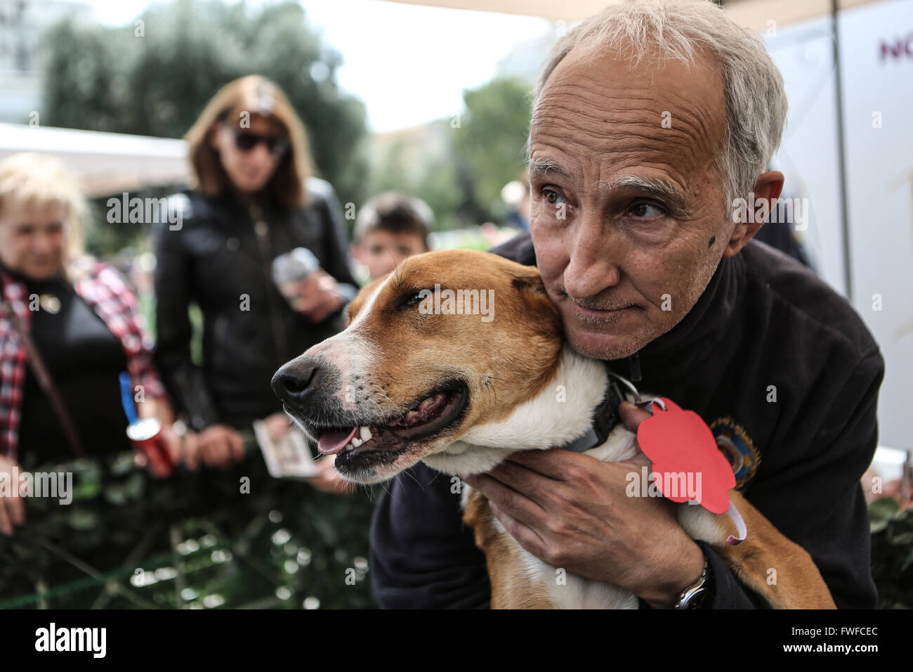 Atenas, Grecia. 3 abr, 2016. Un voluntario abraza a un perro callejero en  el centro de Atenas, Grecia, el 3 de abril de 2016. Docenas de los perros  abandonados tuvo una segunda