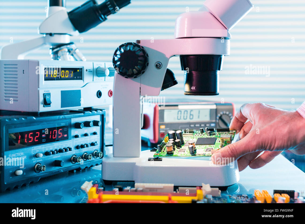 Persona mirando Dispositivos microelectrónicos bajo un microscopio de  laboratorio Fotografía de stock - Alamy
